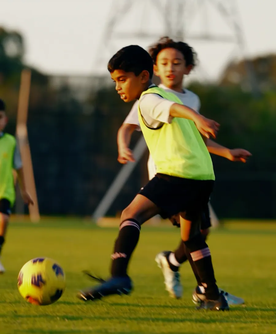 A player shields the ball from a defender during a training drill